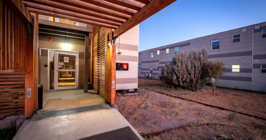 Fotografía de una de las entradas principales del Hotel Village Calama, uno de los proyectos de alojamiento modular más importantes de Tecno Fast Village en el norte de Chile. Ubicado a solo minutos del aeropuerto El Loa y del centro de Calama, este hotel fue diseñado especialmente para trabajadores del sector minero y empresas subcontratistas. La imagen refleja la arquitectura funcional y moderna del edificio, que ofrece más de 400 habitaciones completamente equipadas, el más grande de la zona, además de servicios como salas de capacitación, restaurante, lavandería y áreas de recreación. Una solución integral para operaciones mineras que requieren eficiencia, cercanía y bienestar para sus equipos.